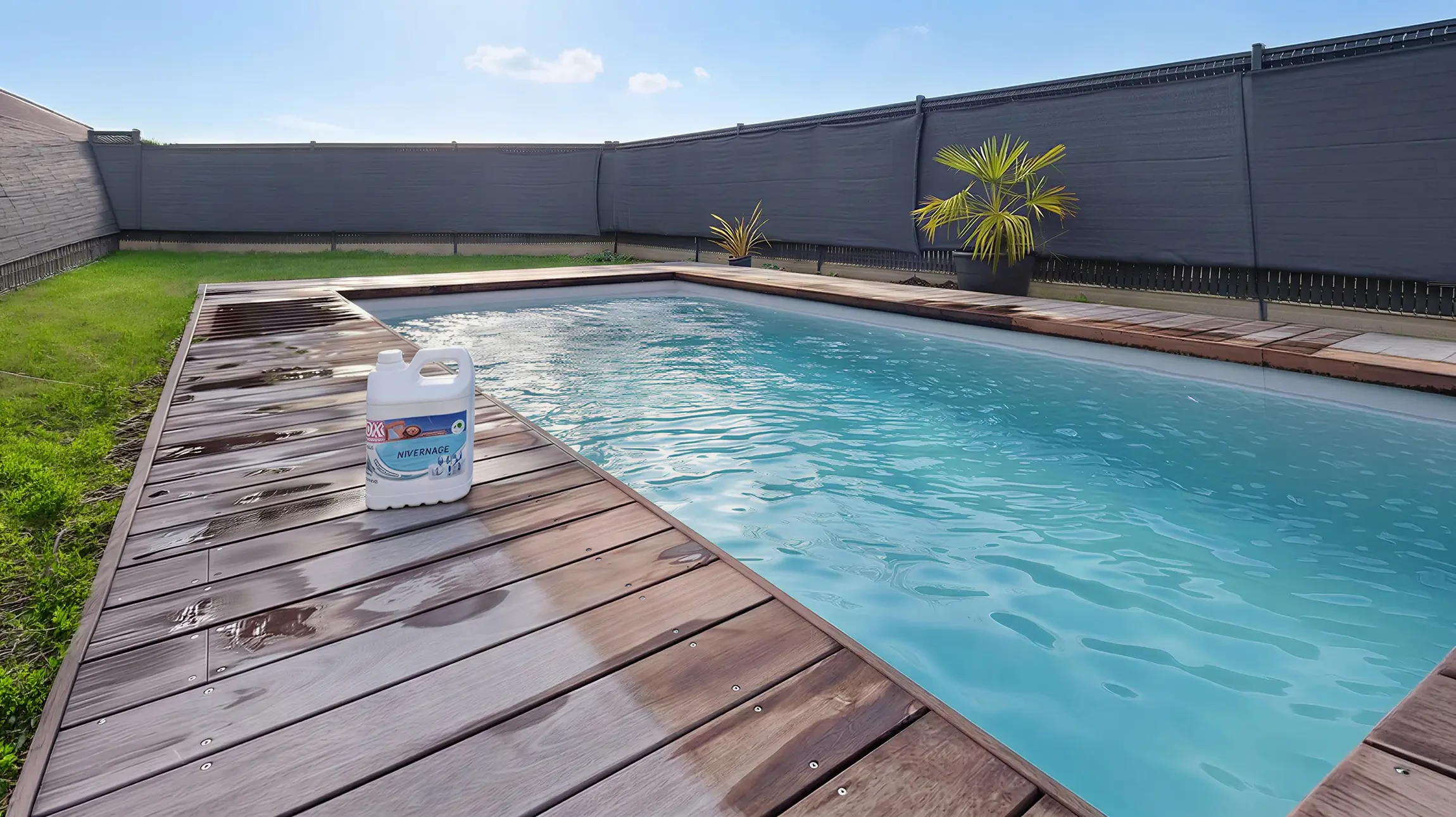 Un technicien en combinaison bleue verse des produits chimiques d'entretien depuis un sachet blanc dans une piscine résidentielle extérieure