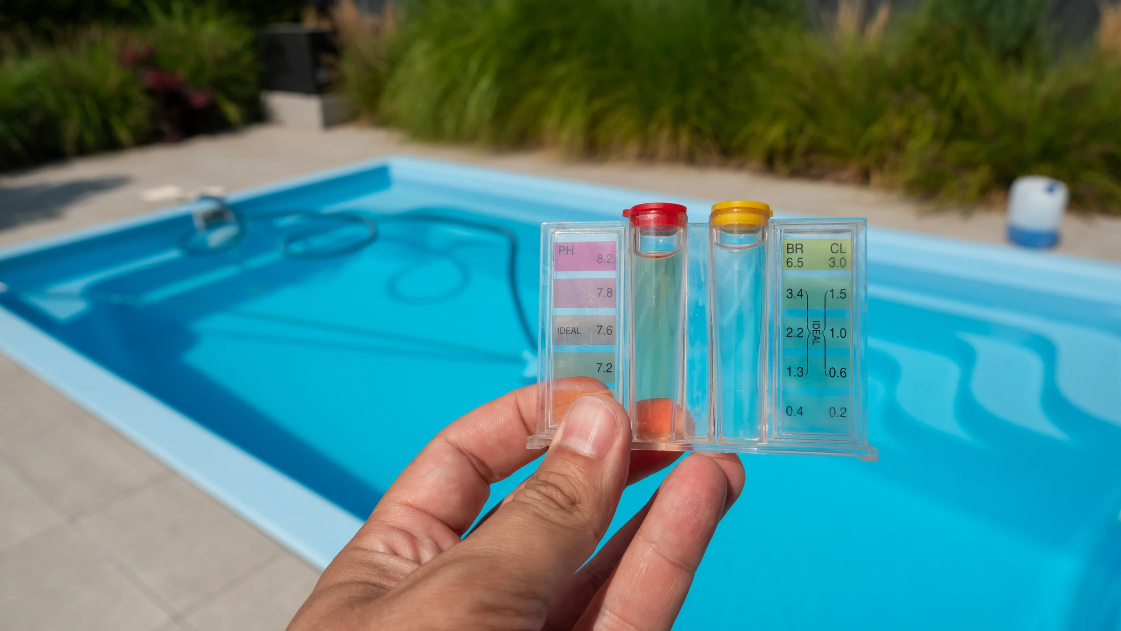Piscine extérieure avec eau cristalline bleu turquoise, échelle métallique chromée intégrée au rebord
