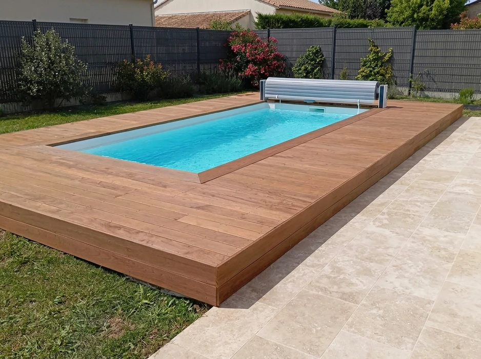 Terrasse en bois composite claire entourant une piscine coque polyester en forme haricot avec fontaine inox