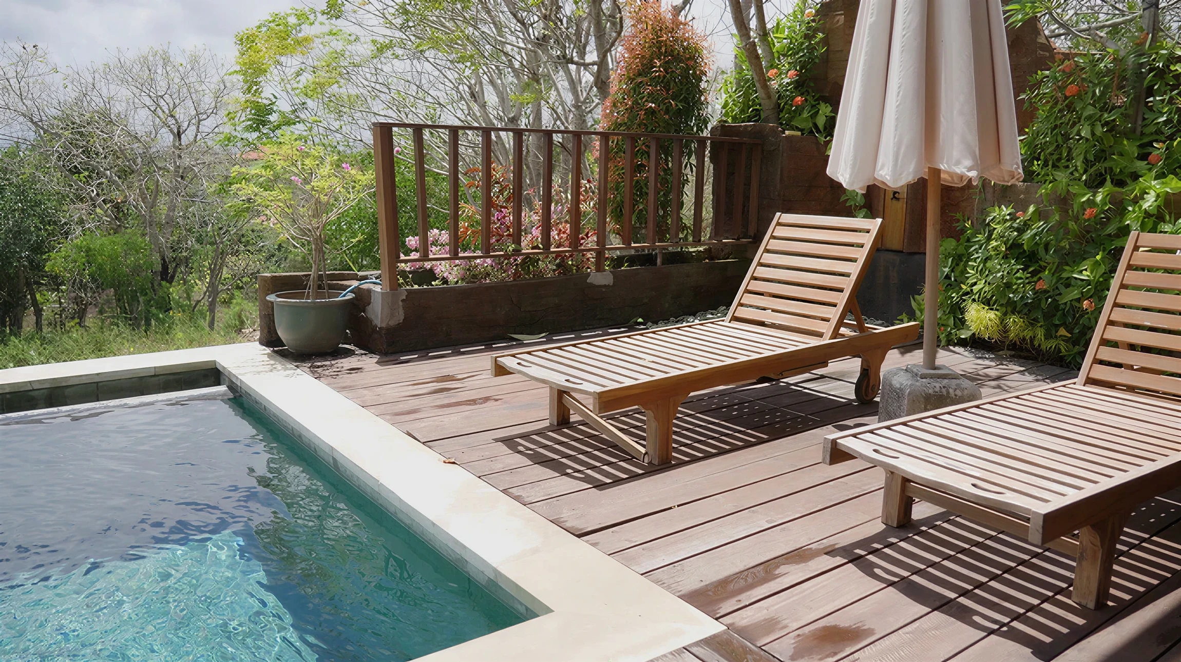 Jardin paysager avec massif de lavande en fleurs violettes au premier plan, piscine à débordement avec margelles en pierre naturelle claire en arrière-plan